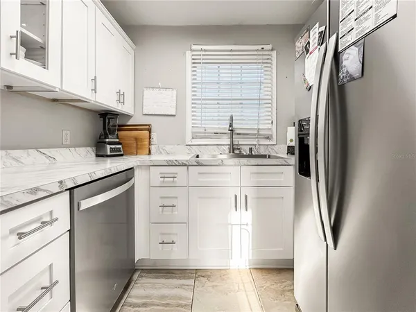 a kitchen with stainless steel appliances granite countertop a refrigerator and a stove