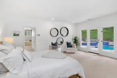 a bedroom with a large bed and two large window