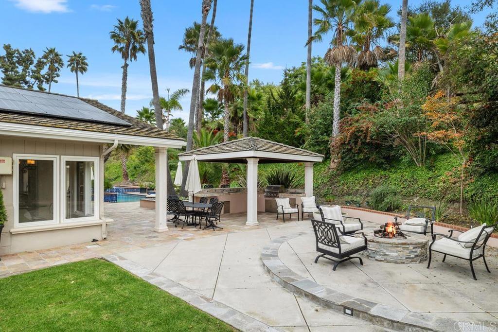 4715 La Noria Rancho Santa Fe, CA 92067 - Photo 19 of 26 a view of a patio with table and chairs potted plants and large tree
