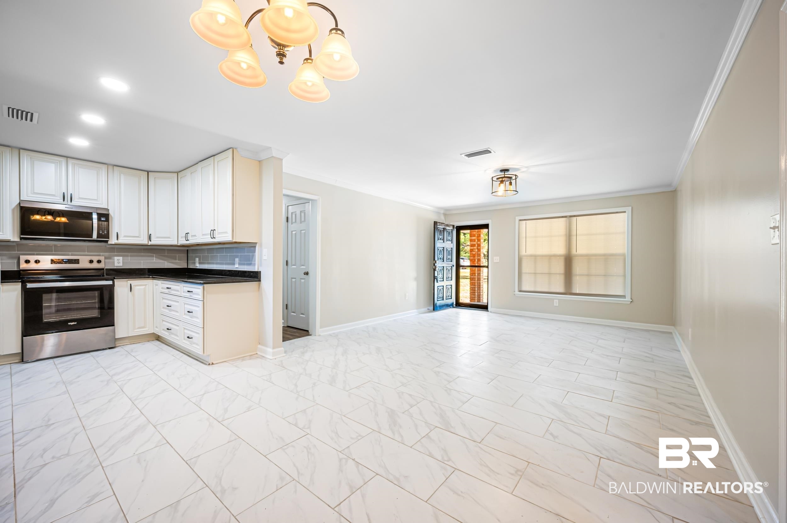 1605 Collier Avenue Bay Minette, AL 36507 - Photo 36 of 36 Kitchen with appliances with stainless steel finishes, decorative backsplash, open floor plan, light marble finish floors, and ornamental molding
