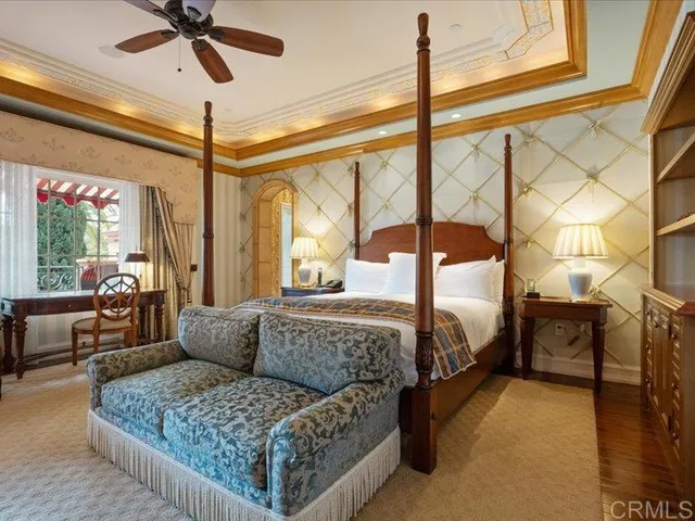 a spacious bedroom with a bed a couch and a chandelier