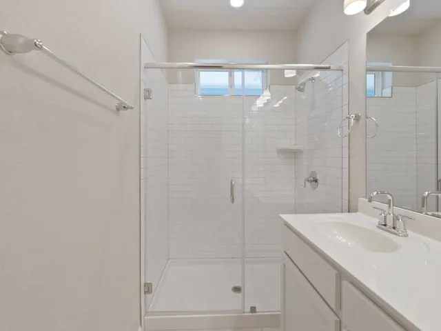 a bathroom with a shower sink and mirror