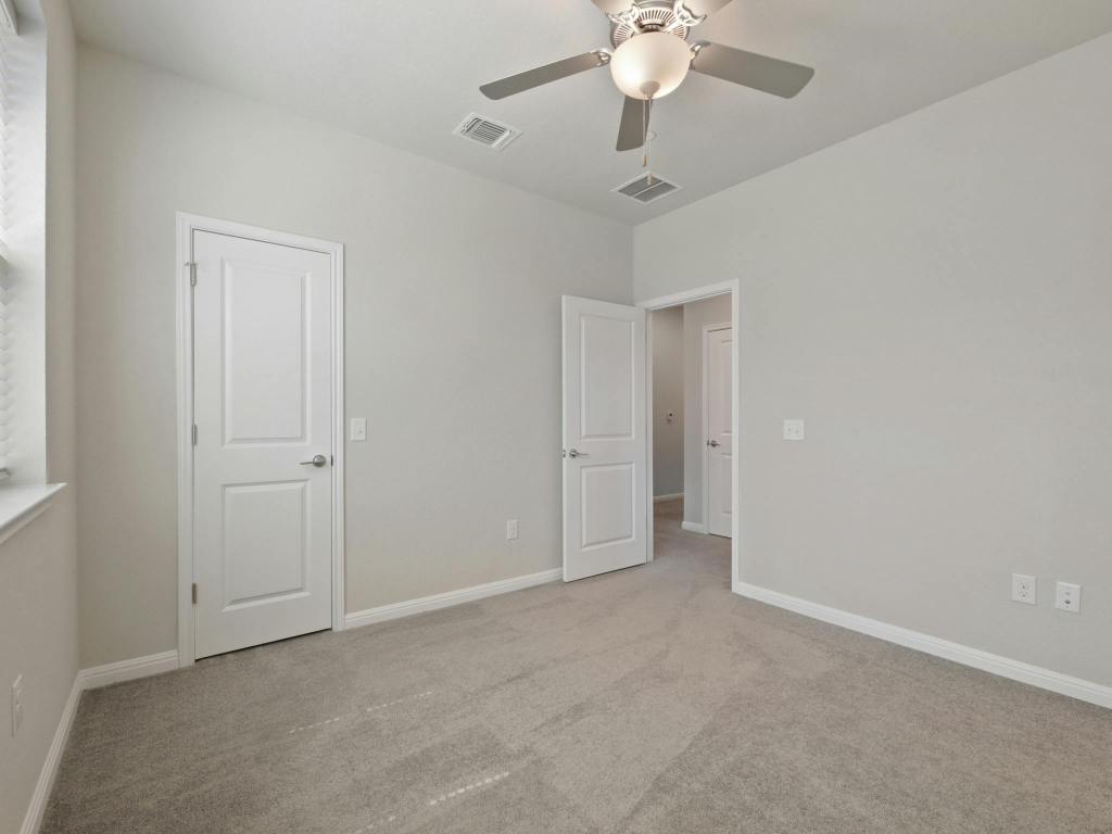 9015 Cattle Baron Path, Unit 2003 Austin, TX 78747 - Photo 19 of 31 an empty room with a chandelier fan and a ceiling fan