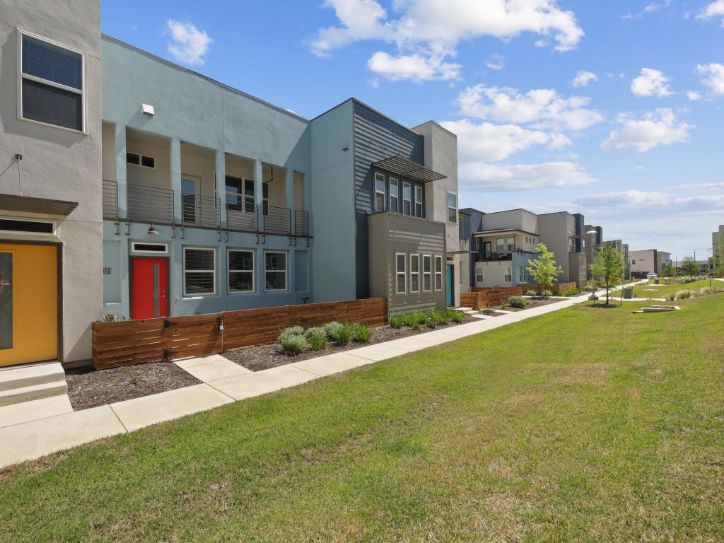 9015 Cattle Baron Path, Unit 2003 Austin, TX 78747 - Photo 2 of 31 a front view of a building with a garden