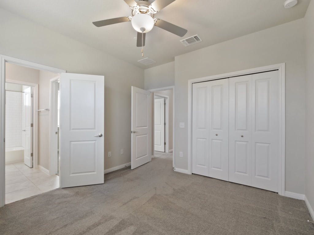 9015 Cattle Baron Path, Unit 2003 Austin, TX 78747 - Photo 21 of 31 an empty room with a chandelier fan and closet area