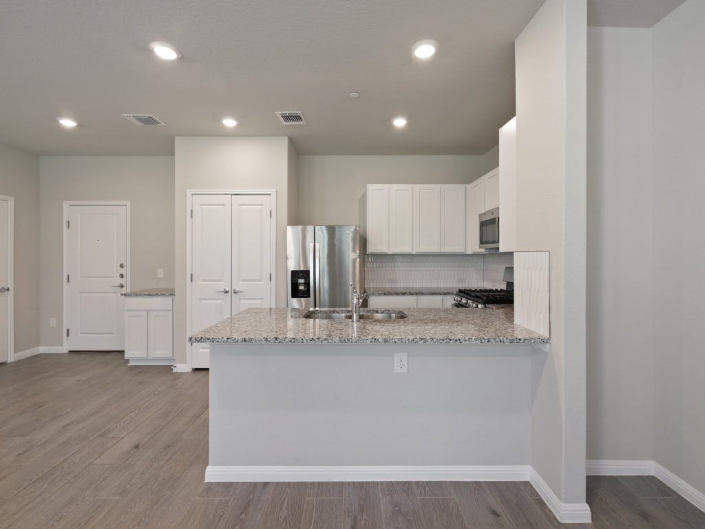 9015 Cattle Baron Path, Unit 2003 Austin, TX 78747 - Photo 9 of 31 a large kitchen with stainless steel appliances granite countertop a stove a sink and a refrigerator