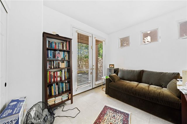 a bedroom with a bed a couch and a large window