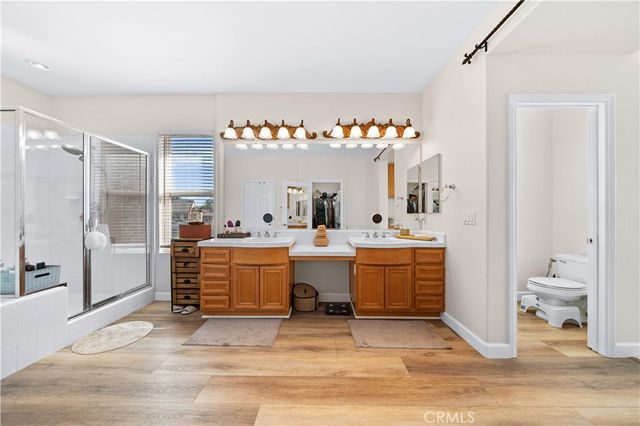 a spacious bathroom with a double vanity sink a mirror and a shower