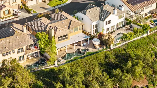 a view of residential houses with swimming pool and green space