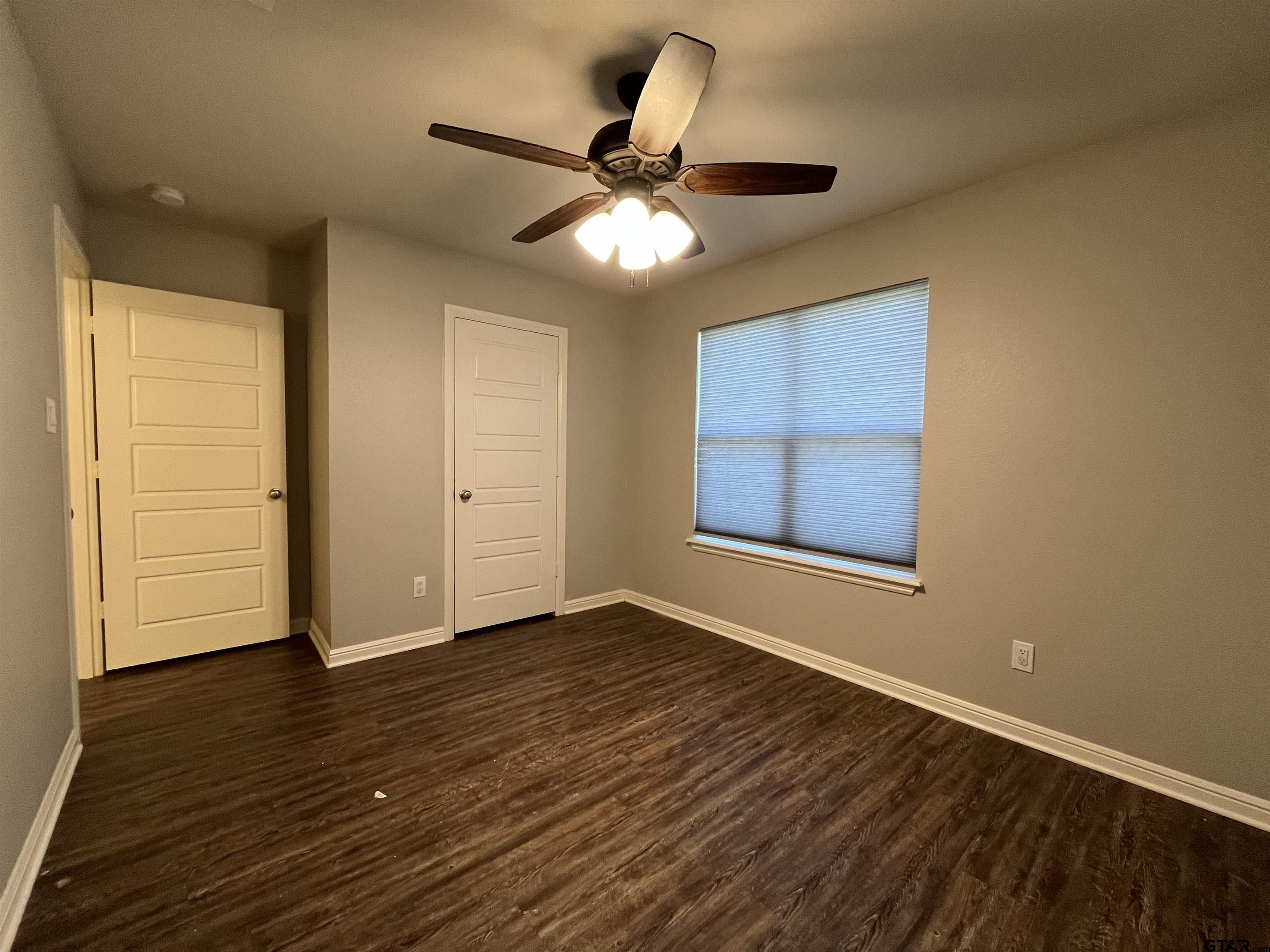 5429 Meadow Ridge Drive Flint, TX 75762 - Photo 13 of 24 a view of an empty room with wooden floor and a window