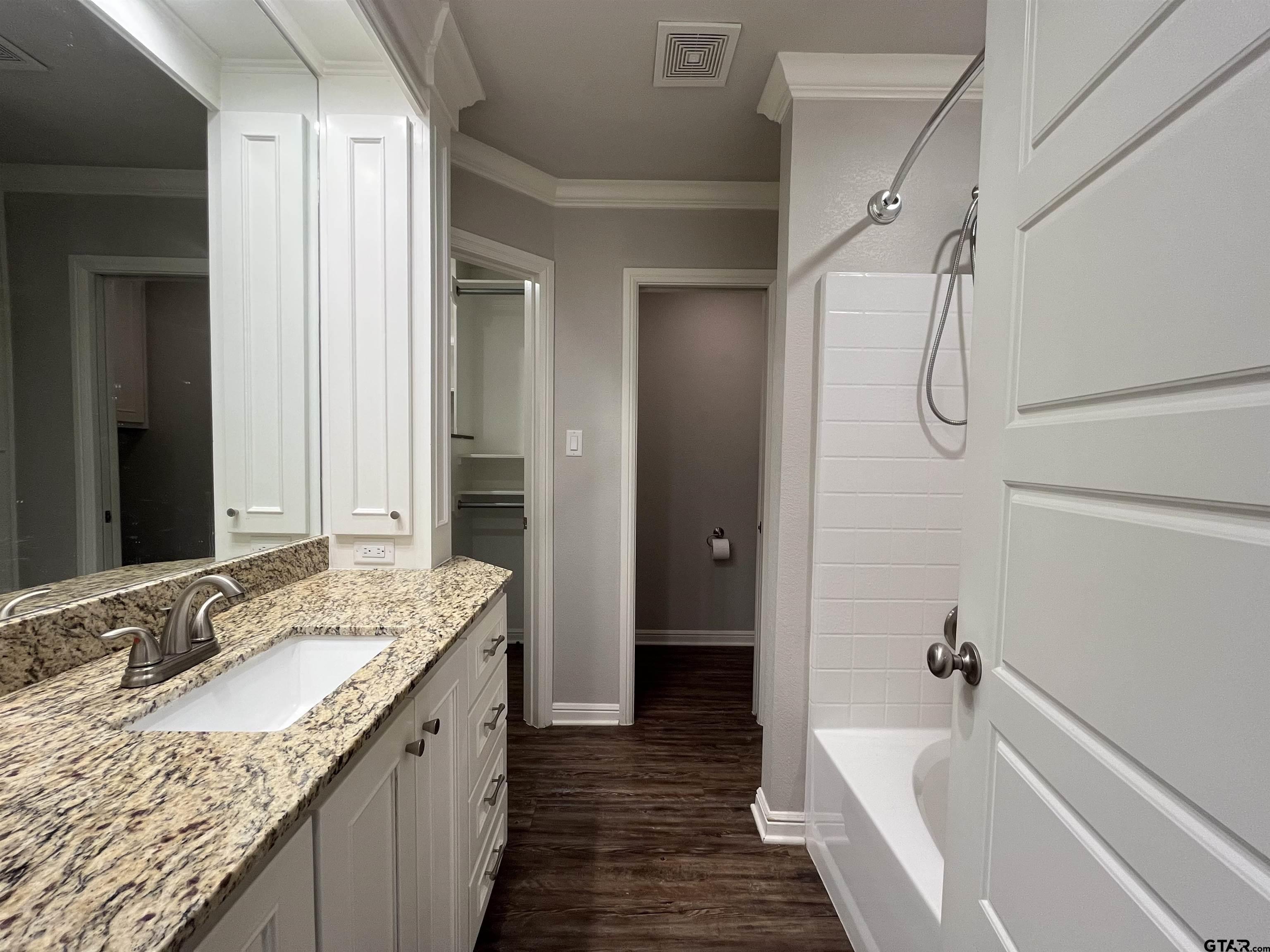 5429 Meadow Ridge Drive Flint, TX 75762 - Photo 18 of 24 a bathroom with a granite countertop sink a mirror and a bathtub