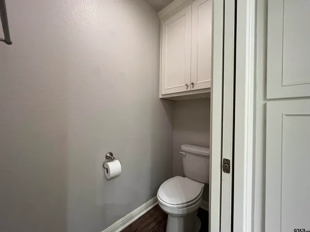 a bathroom with a granite countertop toilet and a sink
