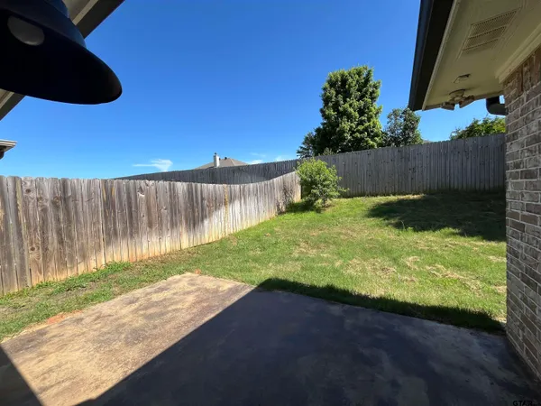 a view of a yard with wooden fence