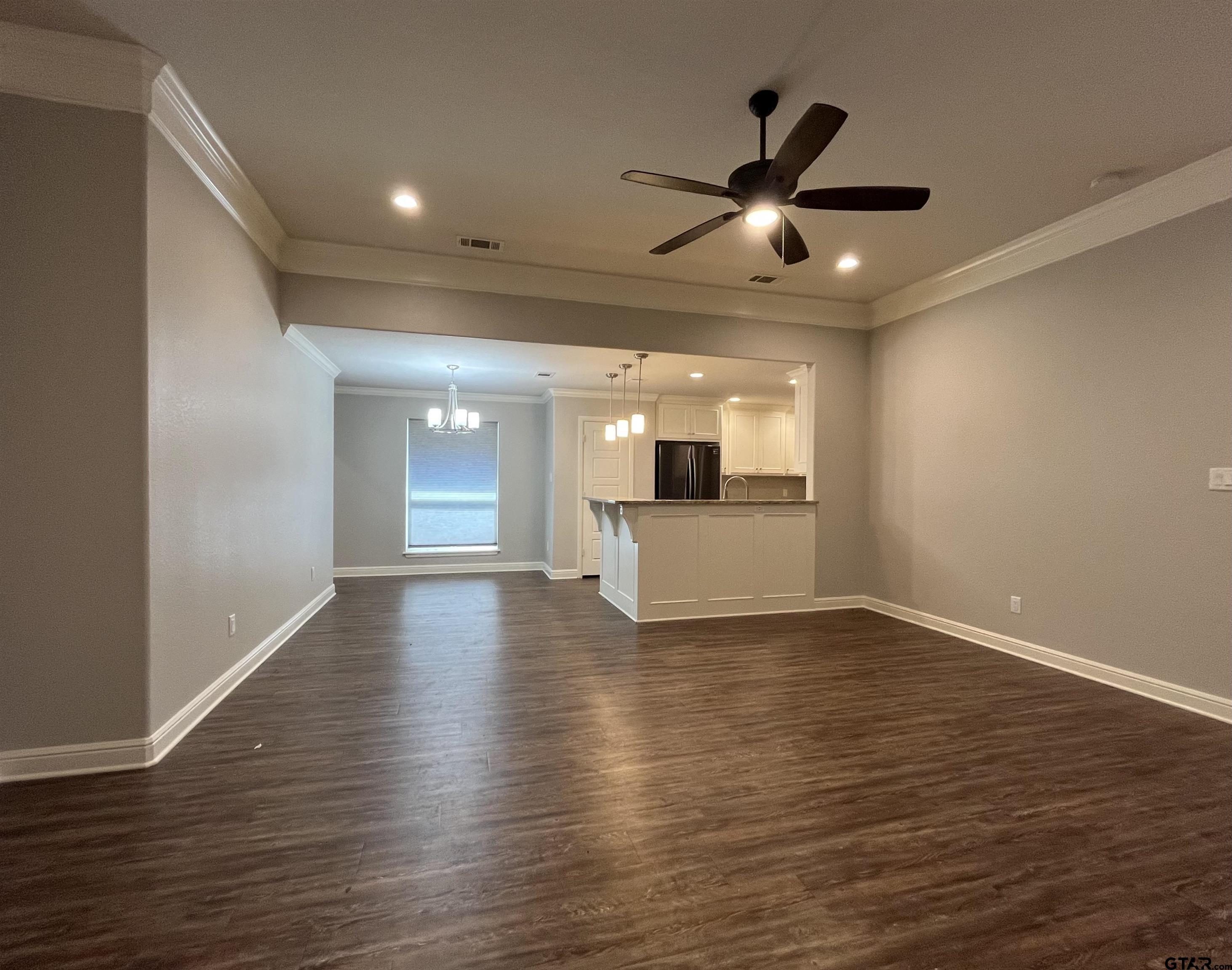 5429 Meadow Ridge Drive Flint, TX 75762 - Photo 4 of 24 a view of an empty room with wooden floor and a ceiling fan