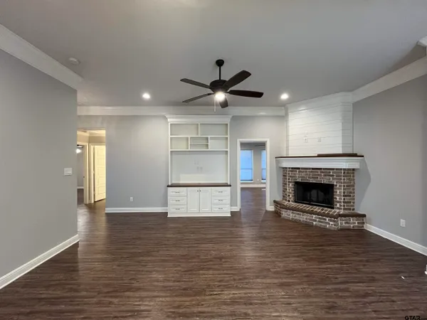 a view of an empty room with a fireplace and a window