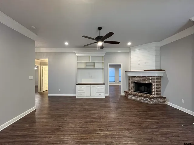 a view of an empty room with a fireplace and a window