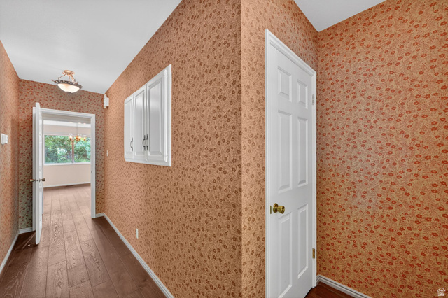 3120 North Apache Way Provo, UT 84604 - Photo 16 of 58 Hallway featuring wood-finish flooring, patterned wallpaper, white trim, and a semi-flush mount light fixture