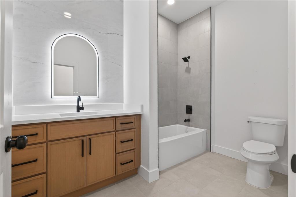 1334 Grant Street Dallas, TX 75203 - Photo 11 of 21 a bathroom with a tub sink toilet and a mirror