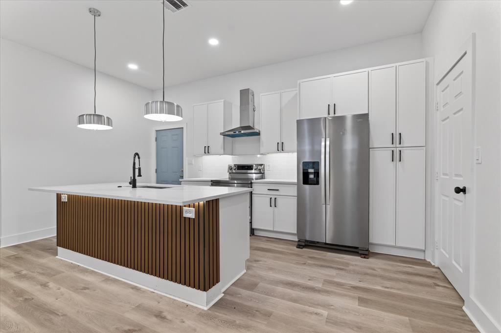 1334 Grant Street Dallas, TX 75203 - Photo 5 of 21 a kitchen with kitchen island white cabinets and stainless steel appliances