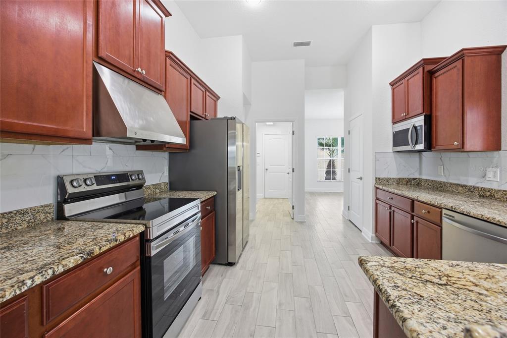 4863 Southwest 63rd Street Ocala, FL 34474 - Photo 12 of 41 a kitchen with stainless steel appliances granite countertop a stove a sink dishwasher and a refrigerator