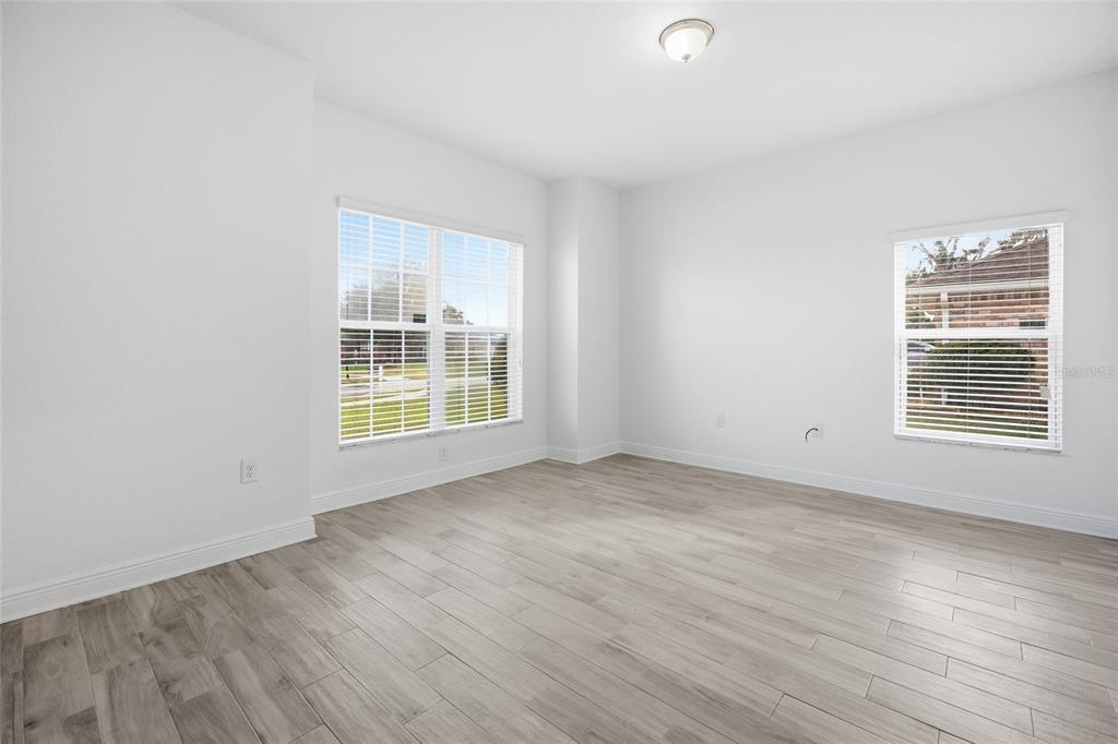 4863 Southwest 63rd Street Ocala, FL 34474 - Photo 15 of 41 a view of an empty room with wooden floor and a window