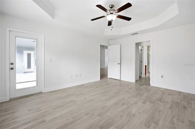 a view of an empty room with a window and wooden floor