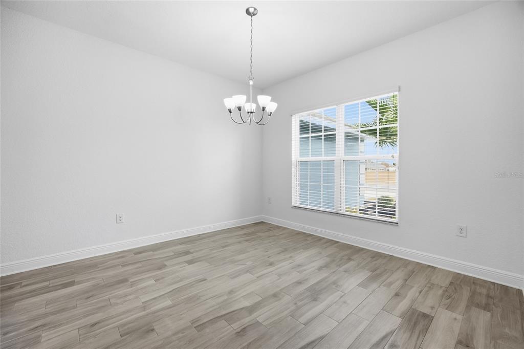 4863 Southwest 63rd Street Ocala, FL 34474 - Photo 7 of 41 an empty room with wooden floor and windows