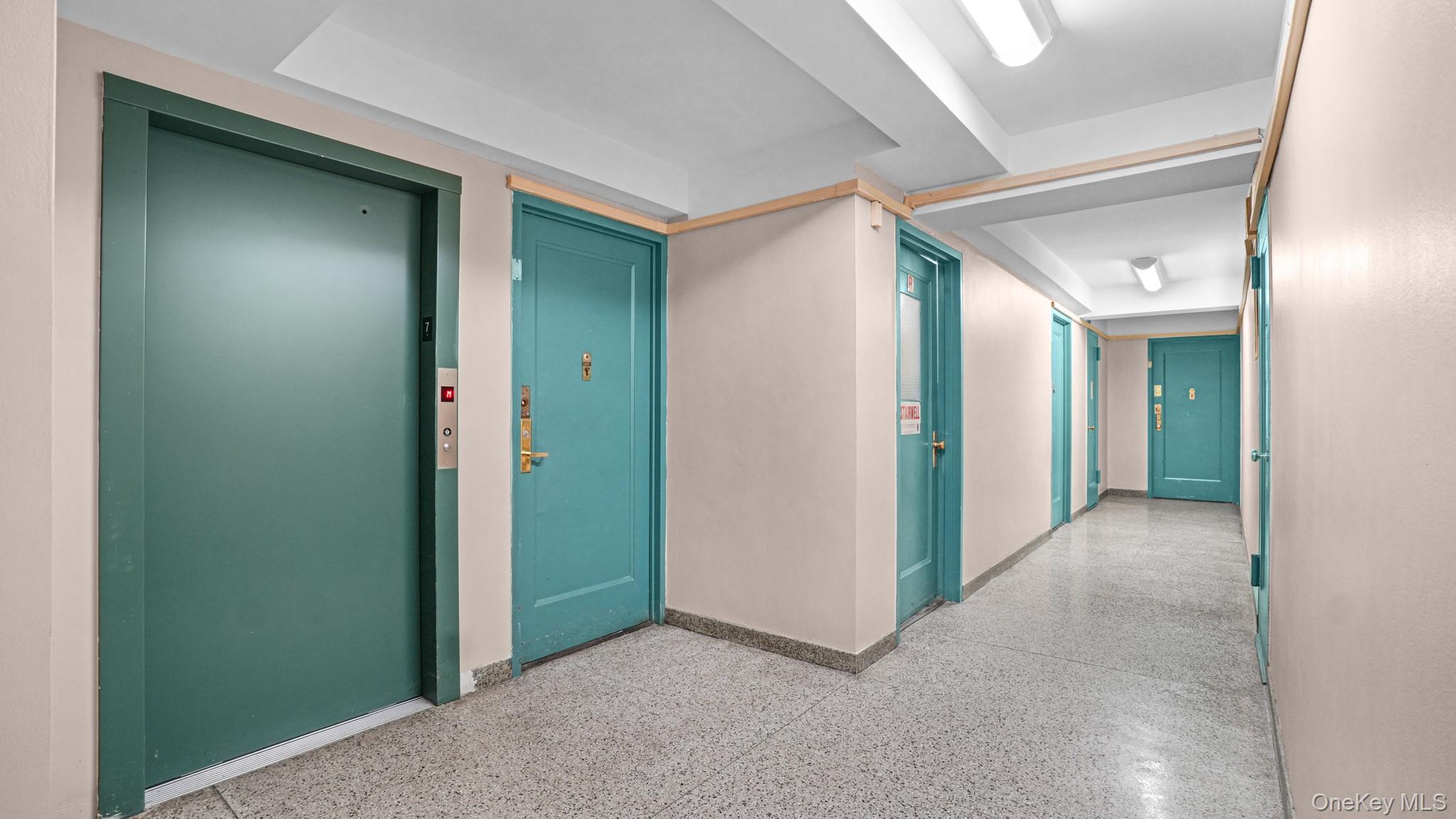 2220 East Tremont Avenue, Unit 7F Bronx, NY 10462 - Photo 11 of 13 Corridor with elevator and dark aggregate flooring