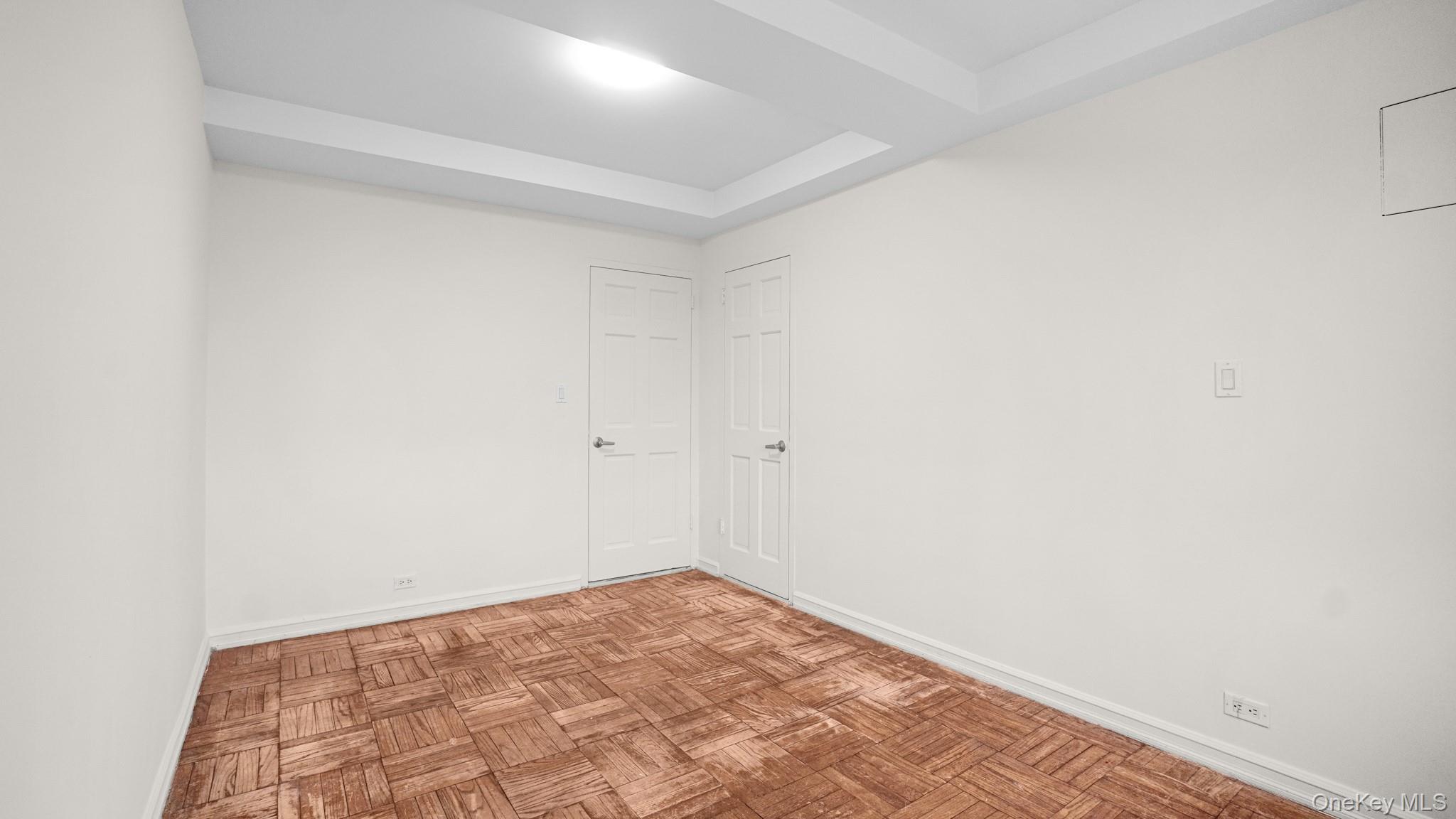 2220 East Tremont Avenue, Unit 7F Bronx, NY 10462 - Photo 8 of 13 Empty room featuring baseboards and a tray ceiling