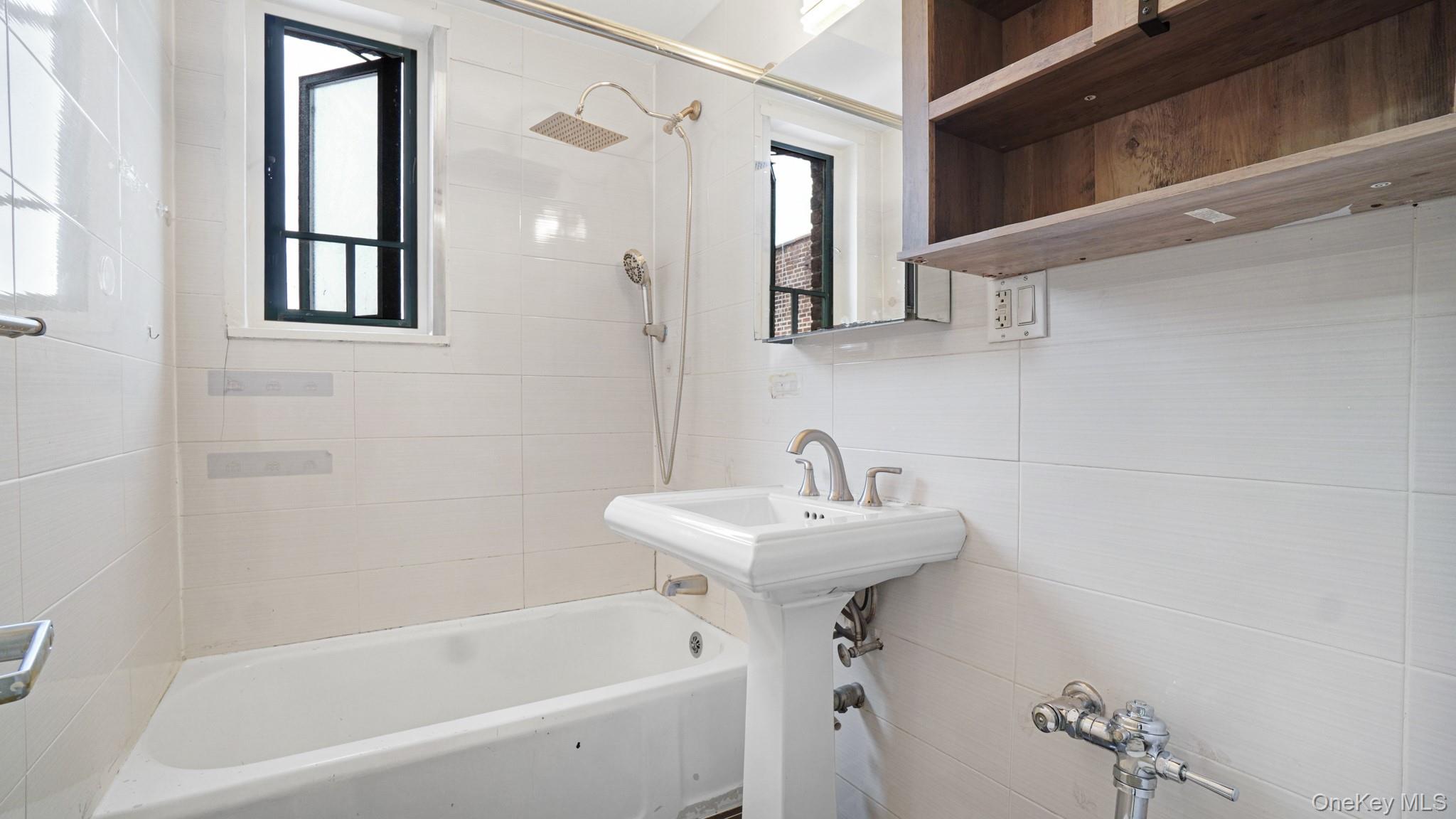 2220 East Tremont Avenue, Unit 7F Bronx, NY 10462 - Photo 10 of 13 Full bathroom with shower combination and tile walls