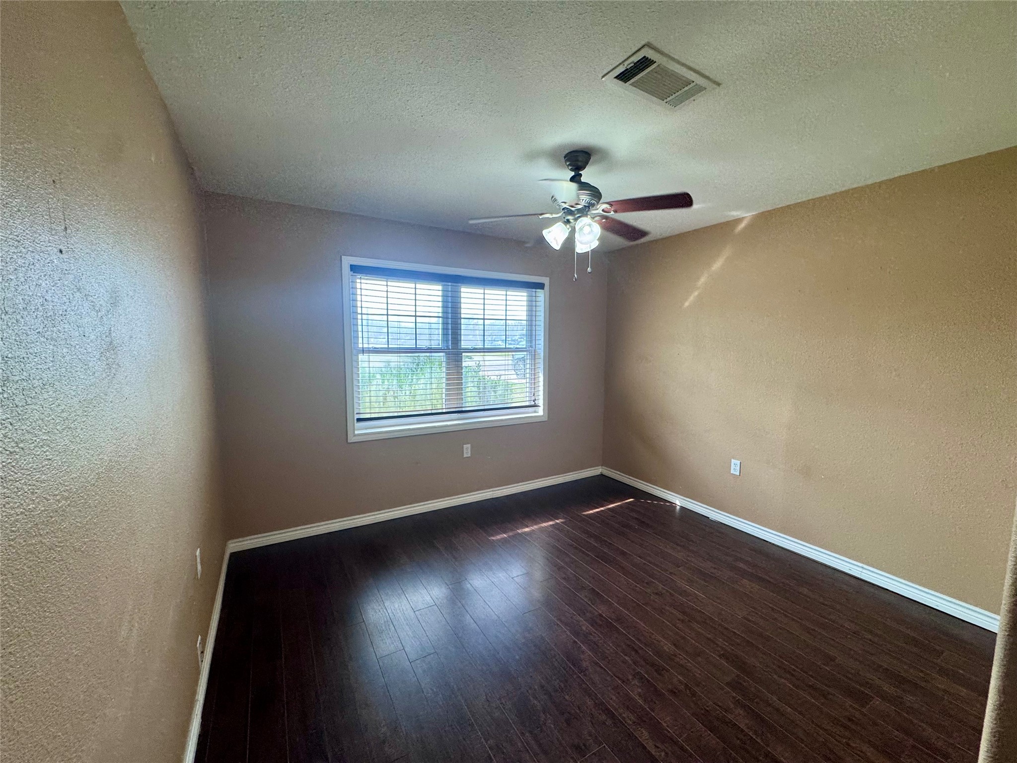 345 Rachal Avenue Bridge City, TX 77611 - Photo 19 of 25 an empty room with wooden floor chandelier fan and windows