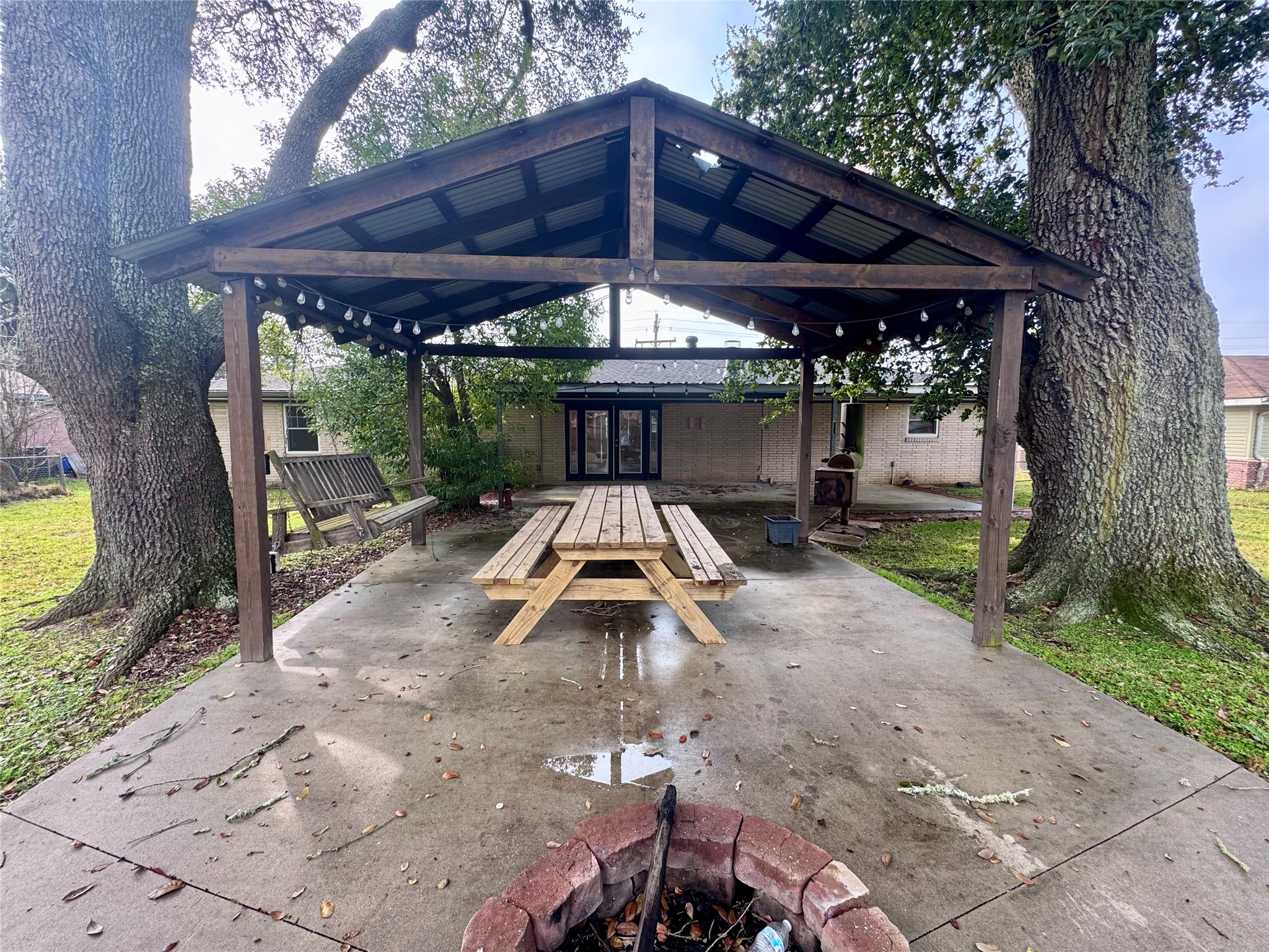 345 Rachal Avenue Bridge City, TX 77611 - Photo 22 of 25 a view of a patio with table and chairs under an umbrella with a large tree