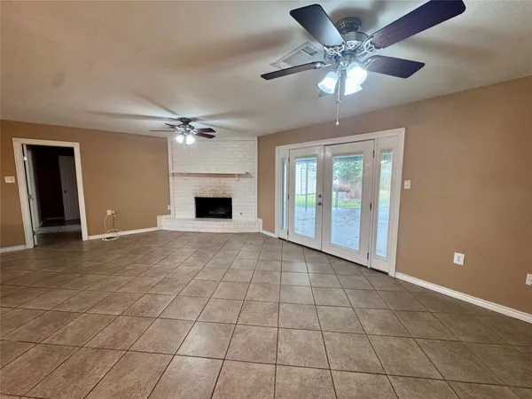 a view of an empty room with a chandelier fan