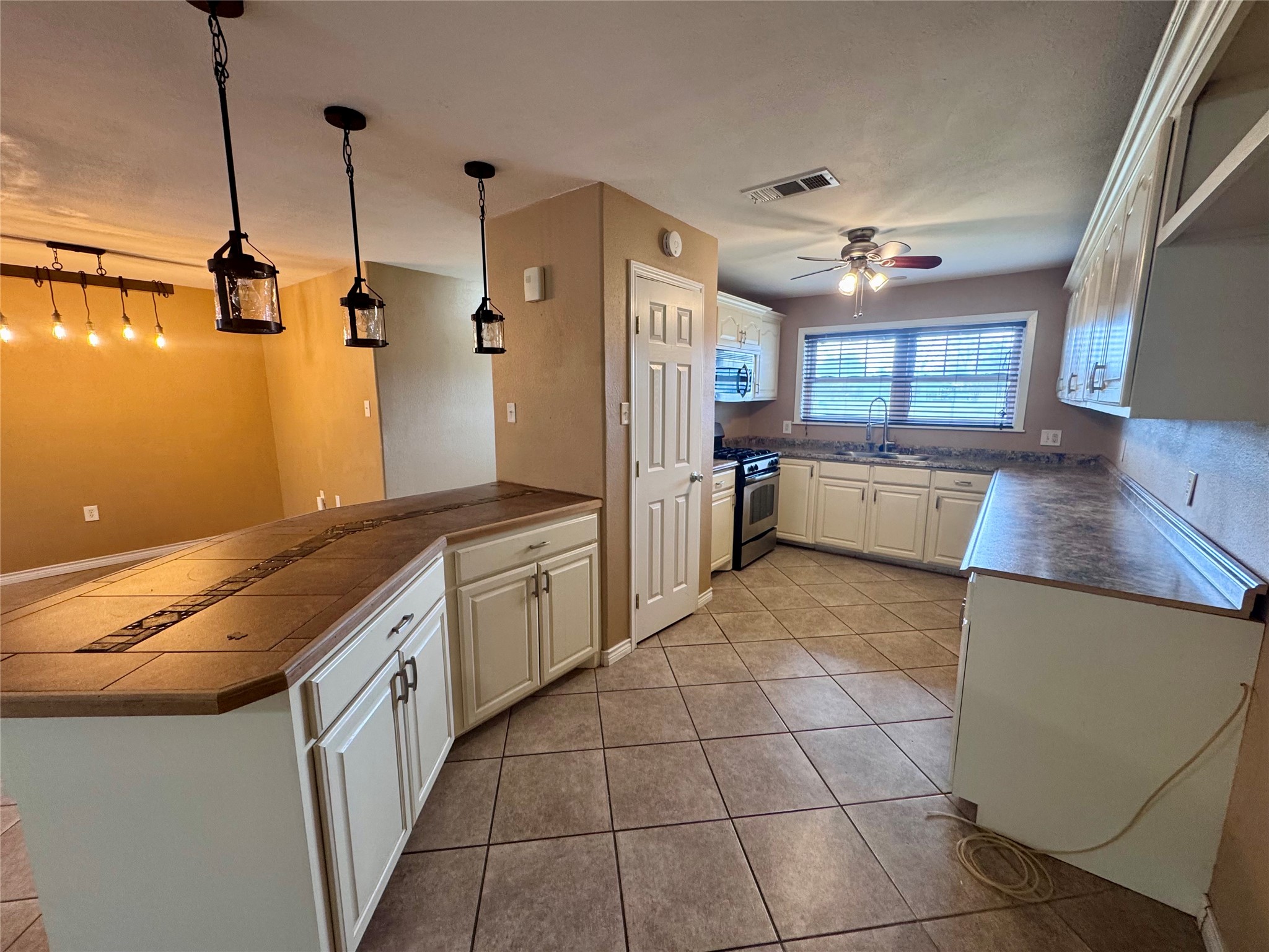 345 Rachal Avenue Bridge City, TX 77611 - Photo 6 of 25 a large kitchen with a stove a sink a refrigerator and a counter space