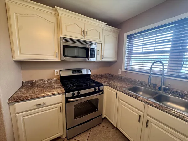 a kitchen with granite countertop cabinets stainless steel appliances and a sink