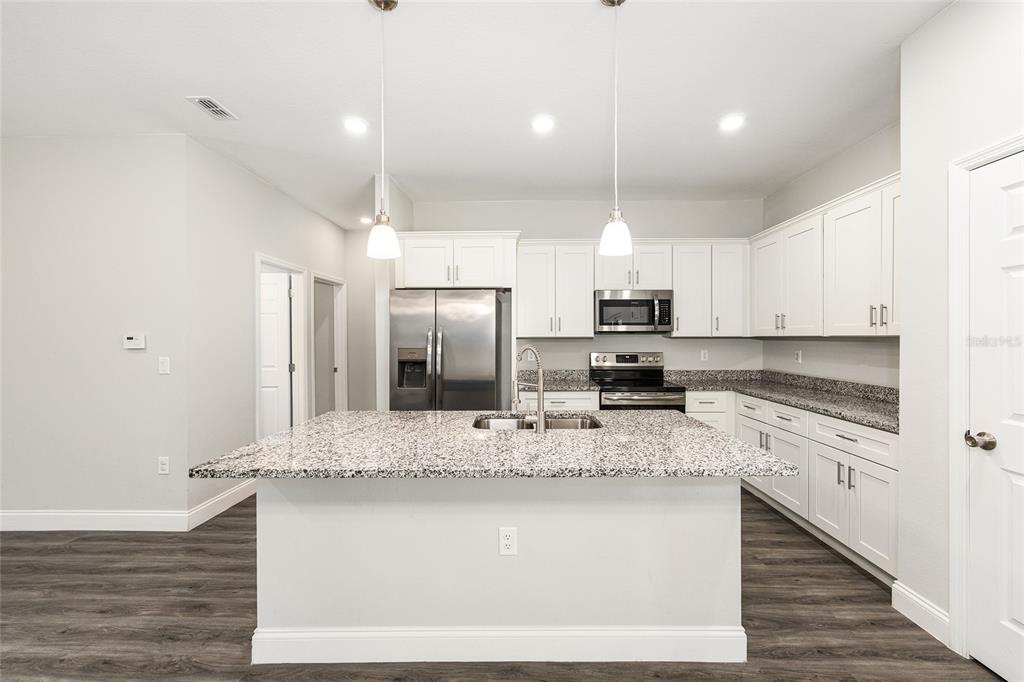 5998 Southwest 154th Street Road Ocala, FL 34473 - Photo 13 of 38 a kitchen with stainless steel appliances granite countertop a sink stove and refrigerator