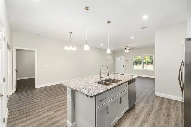 a kitchen that has a sink a window and wooden floor