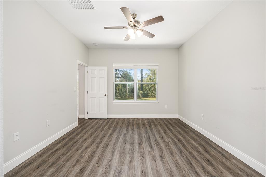 5998 Southwest 154th Street Road Ocala, FL 34473 - Photo 19 of 38 wooden floor in an empty room with a window