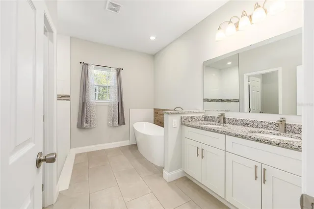 a spacious bathroom with a granite countertop sink a toilet and a mirror
