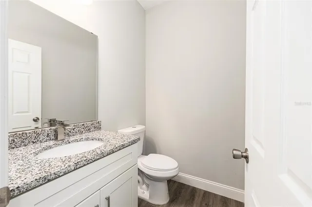 a bathroom with a granite countertop sink a toilet and a mirror