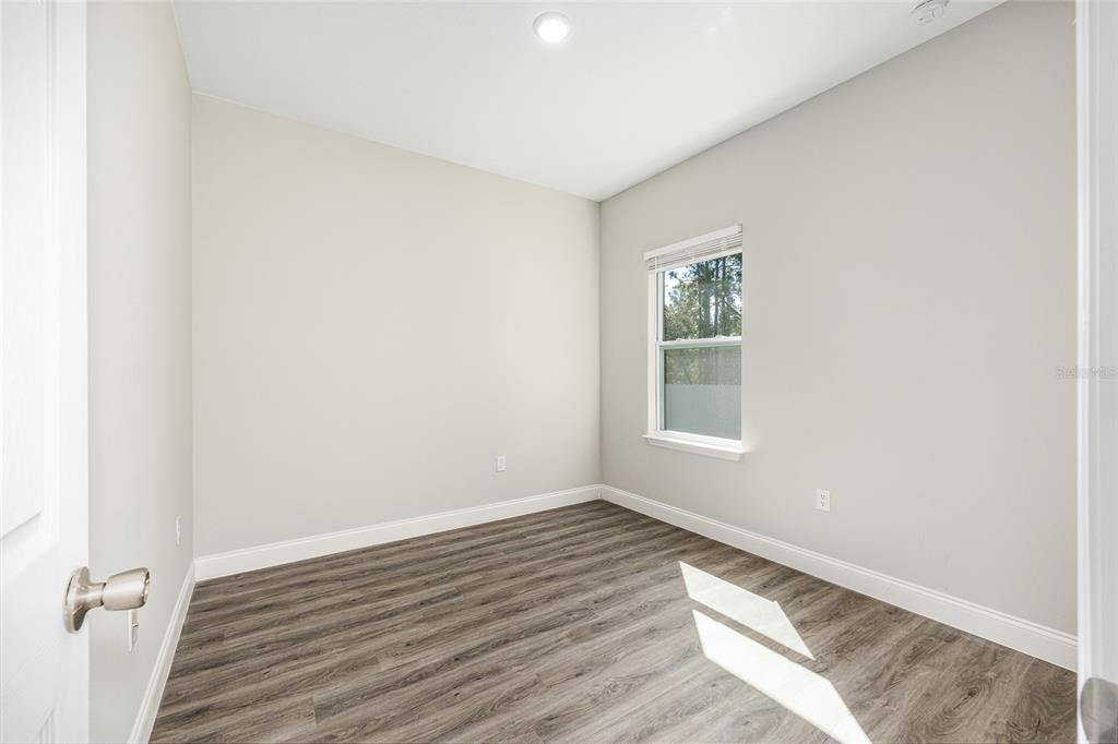 5998 Southwest 154th Street Road Ocala, FL 34473 - Photo 28 of 38 an empty room with wooden floor and windows