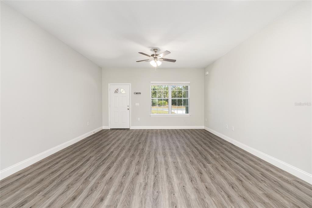 5998 Southwest 154th Street Road Ocala, FL 34473 - Photo 8 of 38 an empty room with wooden floor and windows