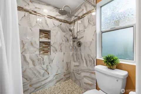 a bath room with a toilet and a shower