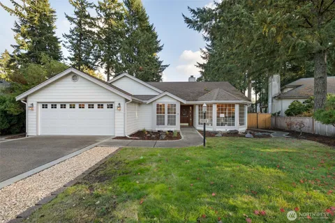 an aerial view of a house with a yard and trees all around