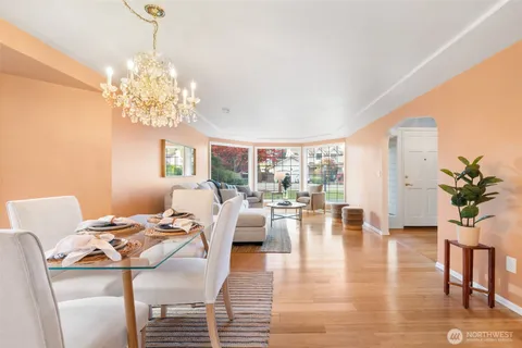 a view of a livingroom with furniture a chandelier and wooden floor
