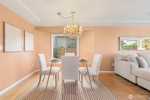 a view of a dining room with furniture a chandelier and wooden floor