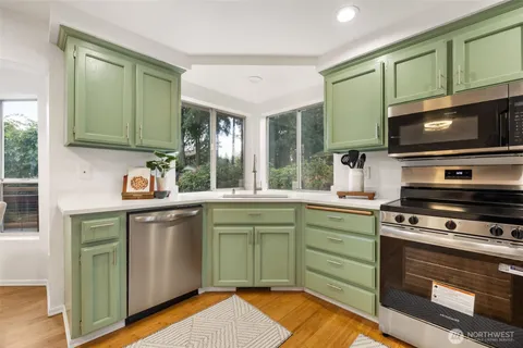 a kitchen with kitchen island granite countertop a sink stainless steel appliances and cabinets