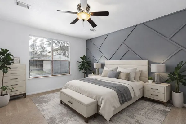 a bedroom with a large bed and a chandelier fan