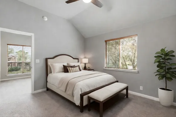 a bedroom with a bed lamp and a potted plant