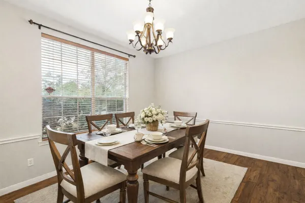 a view of a dining room with furniture a chandelier and wooden floor